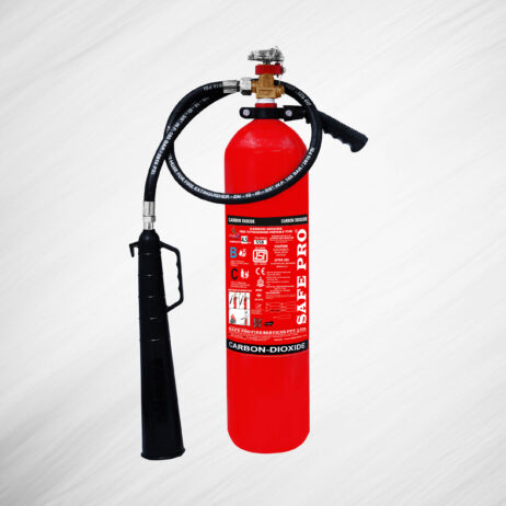 A red carbon-dioxide fire extinguisher with a black hose and nozzle, labeled "Safe Pro," against a light, textured background.